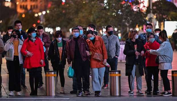 People wearing face masks amid concerns over the COVID-19 coronavirus outbreak walk in Shanghai