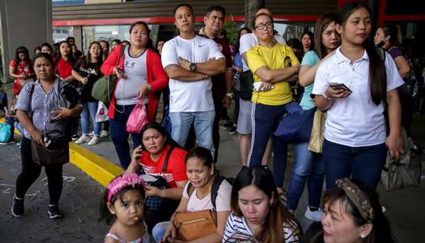 Shoppers and vendors stand outside Virra Mall where gunshots were fired in San Juan City, Metro Manila, Philippines