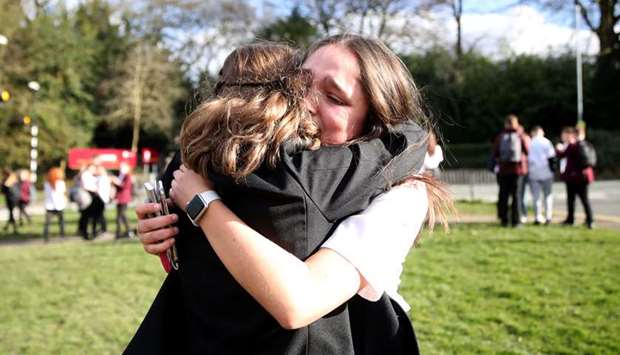 Georgia Mayer, 16, says goodbye to her friend at a school in Newcastle-under-Lyme as the majority of schools in the UK shut while the spread of Covid-19 continues.