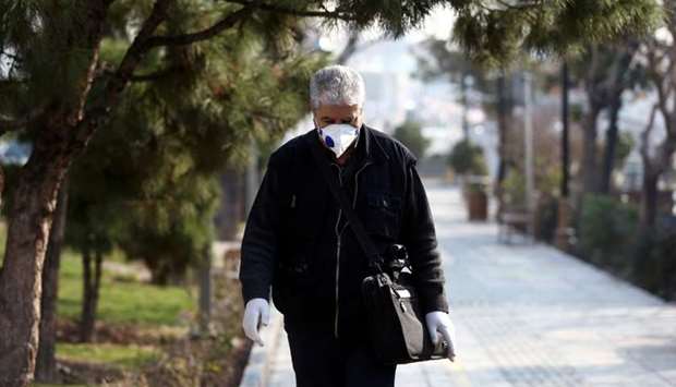 An Iranian man wears a protective mask against the coronavirus as he walks on a street in Tehran, Iran on February 29