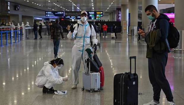 Passengers wearing protective gear, amid concerns of the coronavirus, arriving at Shanghai Pudong International Airport in Shanghai. Under pressure from anxious parents, Chinese citizens living in virus-hit Europe are flocking back home, with some even flying on private jets to escape the spiralling number of infections overseas.