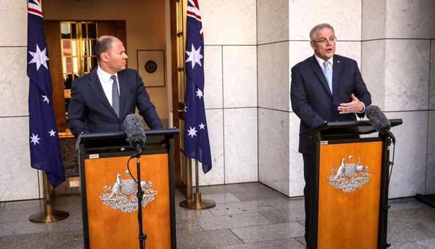 Australian Prime Minister Scott Morrison (R) speaks as he stands with the Australian Treasurer Josh Frydenberg during a press conference at Australia's Parliament House in Canberra