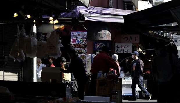 Shoppers walk through the Tsukiji Outer Market in Tokyo. Lockdowns and panic food buying due to the coronavirus pandemic could ignite world food inflation even though there are ample supplies of staple grains and oilseeds in key exporting nations, a senior economist at FAO and agricultural analysts said.