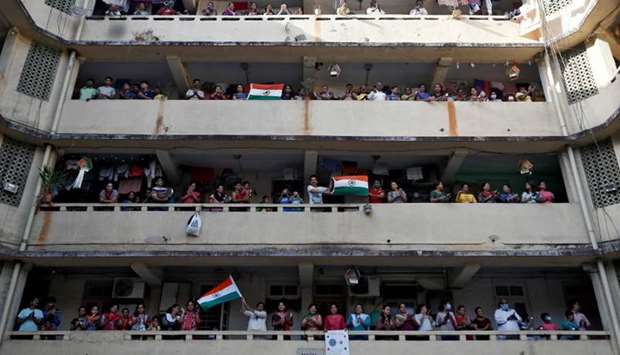People clap and bang utensils from their balconies to cheer for emergency personnel and sanitation workers who are on the frontlines in the fight against coronavirus, in Mumbai