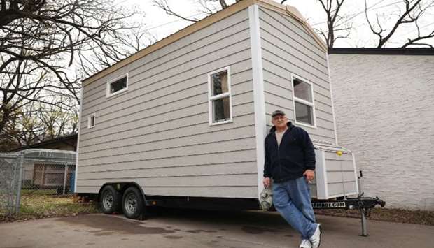 AHEAD OF THE CURVE: Bryan Korbel stands for a portrait near the 224-square-foot tiny house heu2019s building on wheels which he plans to take to his property north of the city in the event of a major terrorist attack or nuclear war.