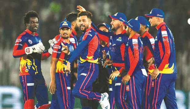 Karachi Kingsu2019 Mohamed Amir (centre) celebrates with teammate after taking the wicket of Peshawar Zalmiu2019s Tom Banton (not in the picture) during their PSL match at the Rawalpindi Cricket Stadium in Rawalpindi yesterday. (AFP)