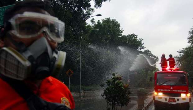 Firefighters spray disinfectant on the road, to prevent the spread of coronavirus disease (Covid-19) in Tangerang, near Jakarta, yesterday.