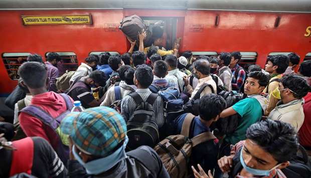Migrant workers and their families board an overcrowded passenger train, after government imposed restrictions on public gatherings in attempts to prevent spread of coronavirus disease, in Mumbai, yesterday.