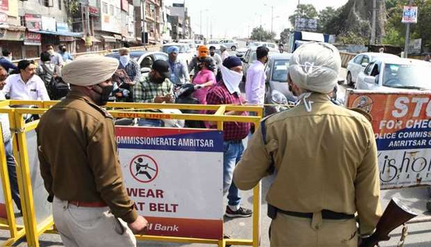 Commuters are stopped by policemen at a checkpoint   following Punjab State government order for a complete lockdown till March 31, with the exception of essential services and commodities, amid concerns over the spread of the COVID-19 novel coronavirus in Amritsar