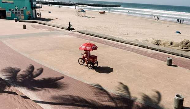 A picture taken on March 19, 2020 shows an ice cream vendor on a tricylce at the deserted north beach in Durban as the eThekwini Municipality places drastic measures to be imposed in all beaches and swimming pools to be prohibited with immediate effect in order to combat the coronavirus (COVID-19) pandemic