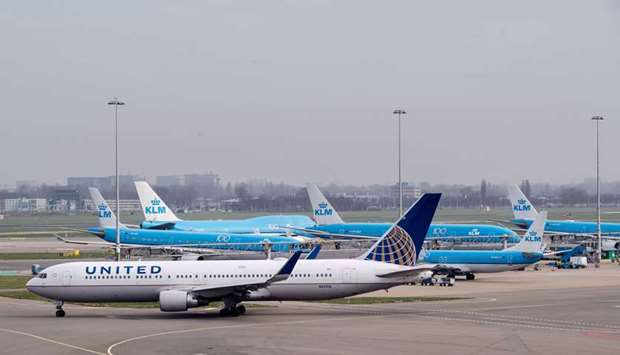 A passenger aircraft operated by United Airlines Holdings taxis beside passenger airplanes operated by KLM at Schiphol Airport, operated by the Royal Schiphol Group, in Amsterdam, Netherlands. On Saturday, United Airlines said it was cancelling 90% of its international flights in April.