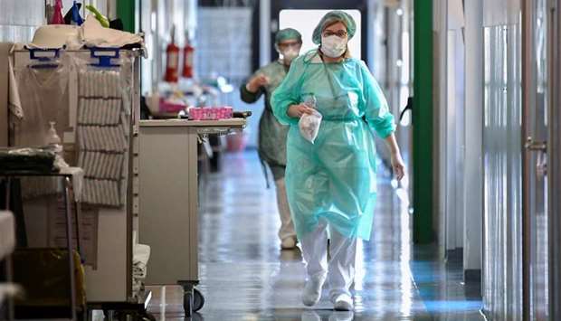 Medical workers wearing protective masks and suits walk in an intensive care unit at the Oglio Po hospital, where patients suffering from coronavirus disease (COVID-19) are treated, in Cremona, Italy