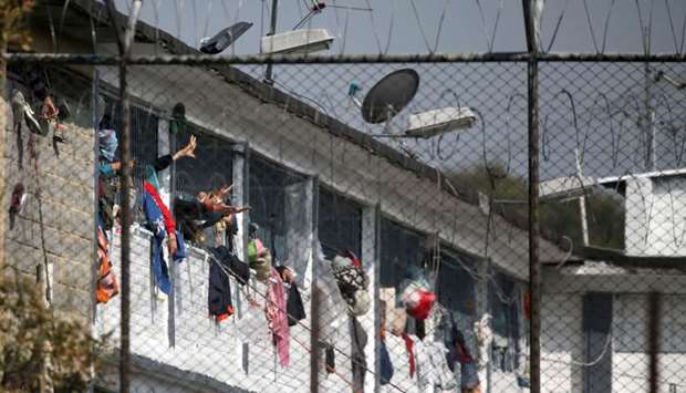 Inmates extend their hands through windows at the Modelo prison in Bogota after a riot.