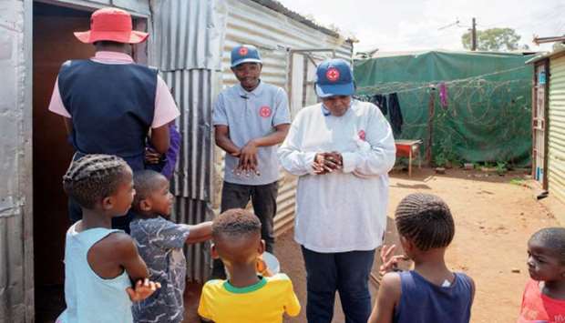 International Red Cross members provide prevention advice to try to contain the Covid-19 coronavirus outbreak, in the Protea informal settlement in Soweto, yesterday.