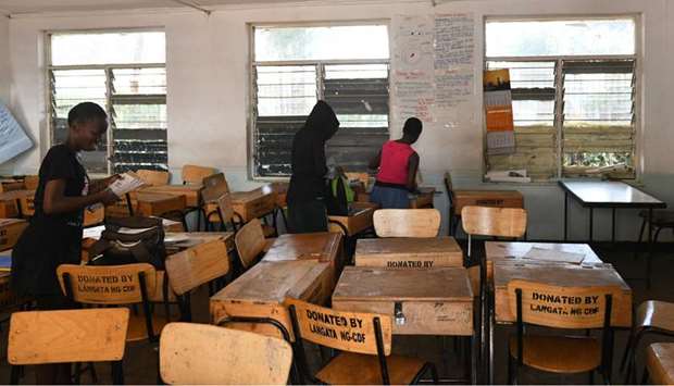 (FILES) In this file photo taken on March 16, school children pack their books to take home, following a directive by the Kenyan government to suspended learning in all institutions of learning as a preventive measure against the spreading of the Covid-19 coronavirus in Nairobi. Close to one billion people worldwide were confined to their homes on March 21, as the global coronavirus death toll shot past 11,000 and US states rolled out lockdown measures already imposed across swathes of Europe. The pandemic has completely upended lives across the planet, restricting movement, shutting schools and forcing millions to work from home.