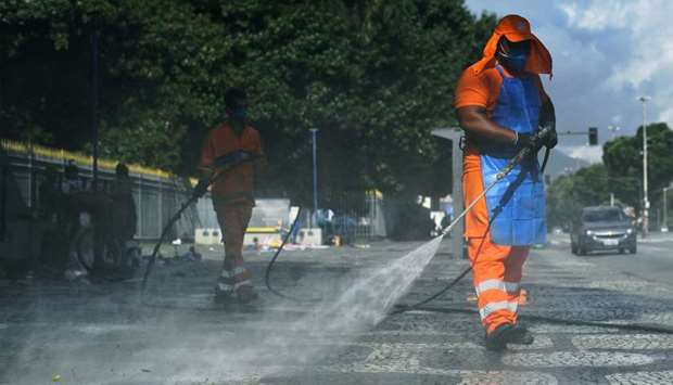 A council worker disinfects the pavement as a measure against the Covid-19 pandemic in Rio de Janeiro, Brazil, yesterday.