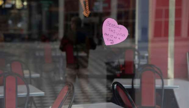A sign hangs in the window of a restaurant in Detroit, reading u2018Beating this virus one heart at a timeu2019.