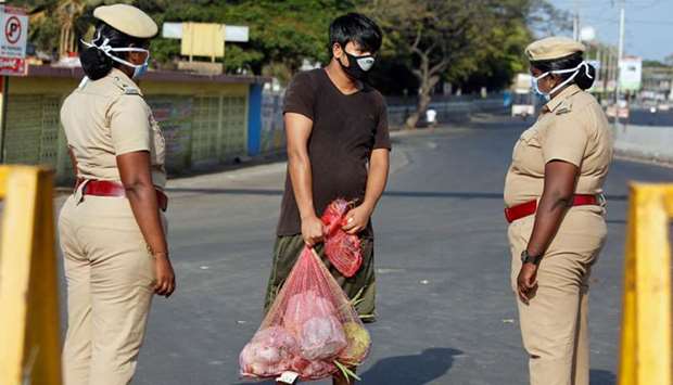 A man carrying vegetables is stopped by police at a barricade on a road in Chennai yesterday.