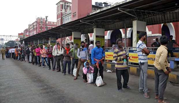 Migrant workers wait in a queue to receive free food outside Howrah railway station in Kolkata yesterday.