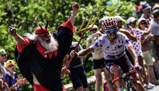 In this file photo taken on July 25, 2018, Franceu2019s Julian Alaphilippe (right) seizes the fork of Tour de France fan Didi Senft (left) during the 17th stage of the race in south-western France. (AFP)