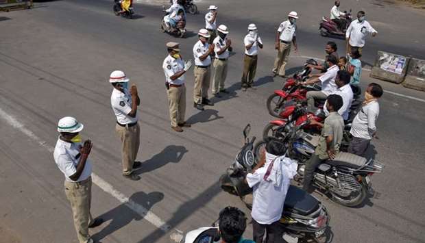 Members of traffic police fold their hands as they request the commuter to wear masks and to stay at home during a 21-day nationwide lockdown to limit the spreading of coronavirus disease (COVID-19), in Vijayawada in the southern state of Andhra Pradesh, India