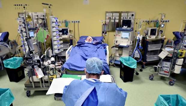 A member of the medical staff in a protective suit is seen in front of a patient suffering from coronavirus disease (COVID-19) in an intensive care unit at the San Raffaele hospital in Milan