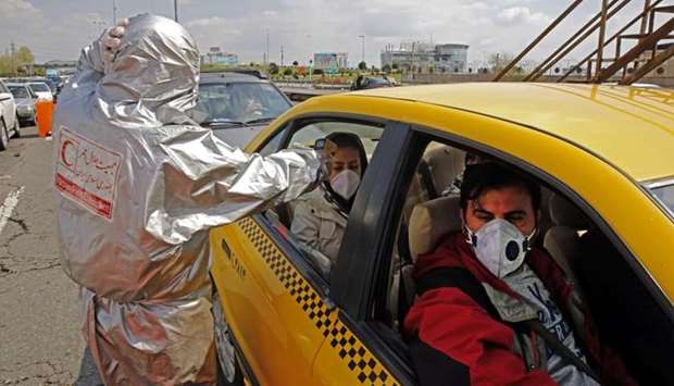 Members of Iranian Red Crescent test people with possible coronavirus Covid-19 symptoms, as police blocked Tehran to Alborz highway to check every car following ordered by the Iranian government, outside Tehran