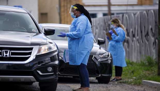 Annette Johnson, outreach coordinator at Odyssey House Louisiana (OHL) which runs a drive-through testing site, has a consultation with a driver to see if she should be tested for the coronavirus disease (COVID-19) in New Orleans, Louisiana