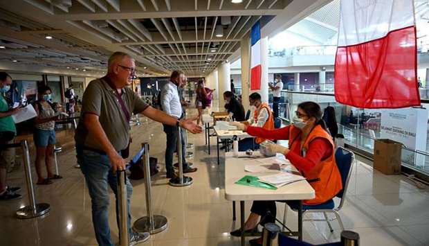 Stranded tourists register with French embassy staff ahead of their evacuation flight amid concerns from the Covid-19 coronavirus at the Ngurah Rai international airport near Denpasar, resort island of Bali, yesterday.