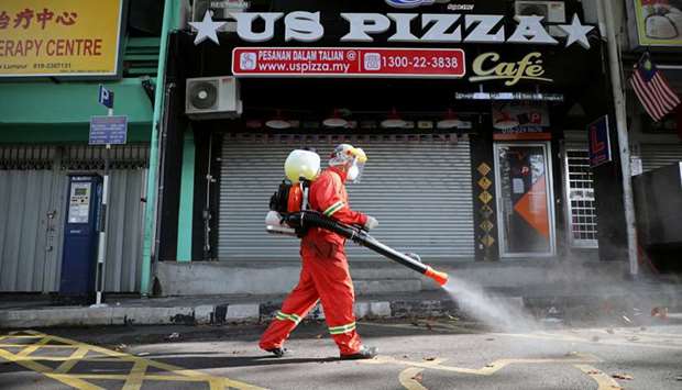 A worker sprays disinfectant on a street during the movement control order due to the outbreak of the coronavirus disease (Covid-19), in Kuala Lumpur yesterday.