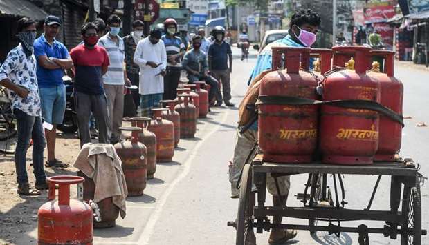 People wait with their empty domestic gas cylinders outside a delivery centre to collect refilled cylinders, in Howrah on the outskirts of Kolkata yesterday.