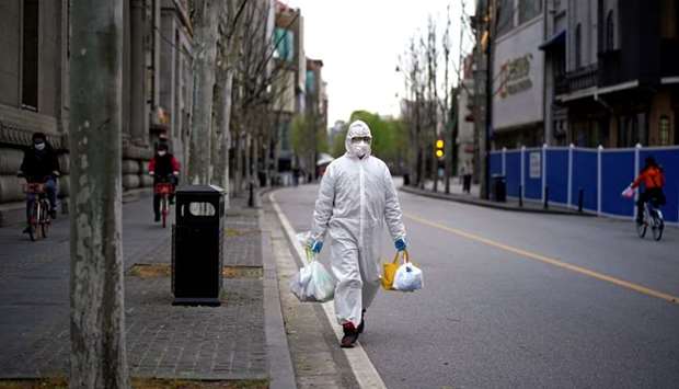 A man wearing a hazmat suit walks on a street in Wuhan, Hubei province, the epicenter of China's coronavirus disease (Covid-19) outbreak