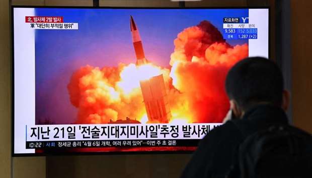 A man watches a news broadcast showing file footage of a North Korean missile test, at a railway station in Seoul