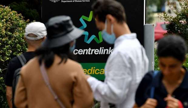 People wait in a queue to receive benefit payouts, including unemployment and small business support as the novel coronavirus inflicts a toll on the economy, at a Centerlink payment centre in downtown Sydney on March 27.