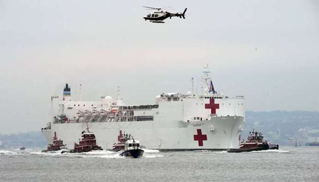 The USNS Comfort medical ship moves up the Hudson River past the Statue of Liberty as it arrives in New York.