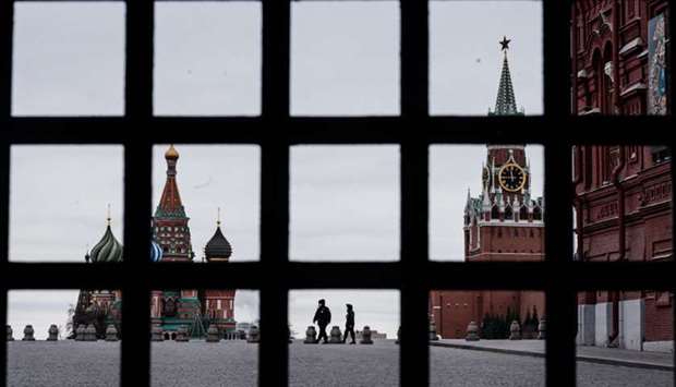 Police officers patrol on the deserted Red Square, with the St Basilu2019s Cathedral (left) and Kremlinu2019s Spasskaya Tower (right) in the background, in Moscow yesterday during a lockdown of the city.