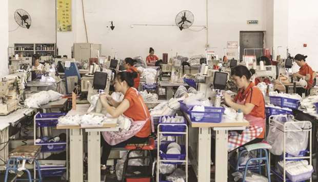 Workers operate sewing machines on the footwear production line at the Anta Sports Products factory in Jinjiang, Fujian. Chinau2019s official manufacturing Purchasing Manageru2019s Index (PMI) is forecast to rise to 45 in March, from a record low of 35.7 a month earlier, according to the median forecast of 18 economists polled by Reuters.