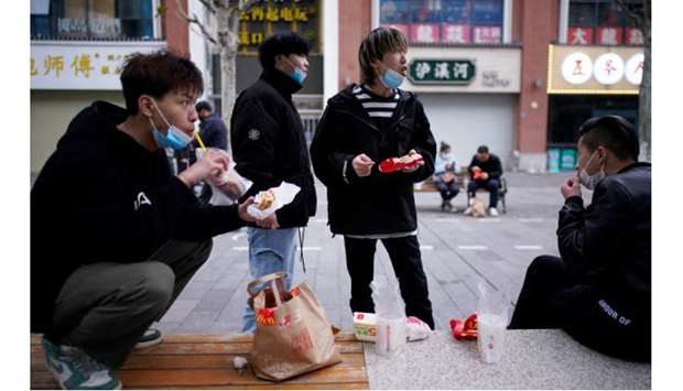 #People with face masks eat outside a McDonaldu2019s restaurant in Wuhan.