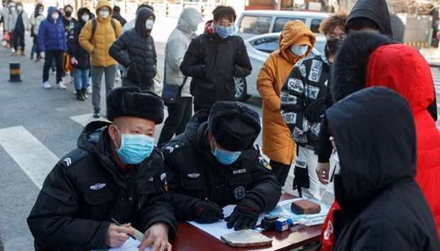 People register their temperature and personal details as they arrive for work at an office building in Beijing, as the country is hit by an outbreak of the novel coronavirus, China
