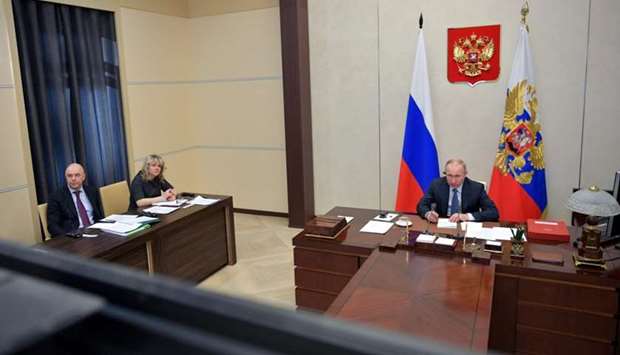 Russian President Vladimir Putin and Finance Minister Anton Siluanov take part in a video link, held by leaders from the Group of 20 to discuss the coronavirus pandemic and its economic impacts, at his residence outside Moscow, Russia on March 26