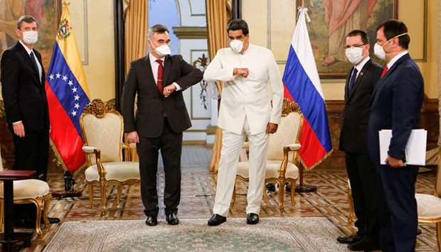 Venezuelau2019s President Nicolas Maduro and Russiau2019s ambassador in Venezuela Sergey Melik-Bagdasarov touch their elbows while wearing masks due to coronavirus disease, at Miraflores Palace in Caracas.