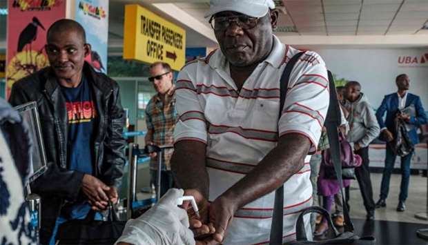 Passengers arriving on international flights are asked to desinfect their hands at Entebbe Airport as they are screened for signs of the novel coronavirus