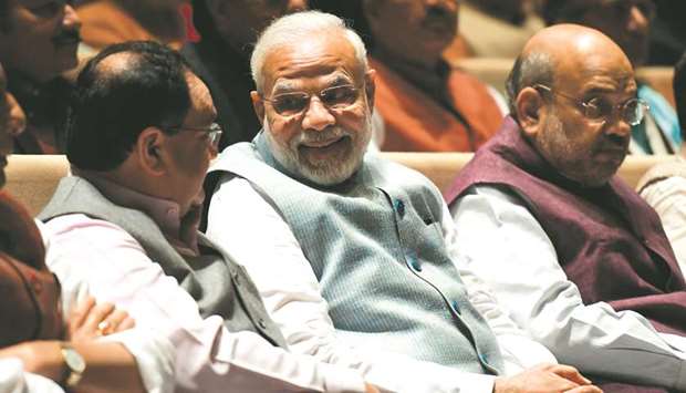 Prime Minister Narendra Modi talks with Bharatiya Janta Party (BJP) president Jagat Prakash Nadda as Home Minister Amit Shah looks on during a Bharatiya Janata Party parliamentary meeting in New Delhi yesterday.