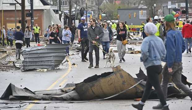 People view damage along Woodland Street after a tornado touched down yesterday in Nashville, Tennessee.