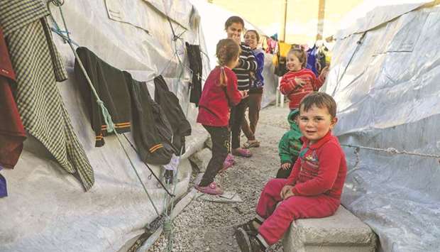 Syrian children displaced by the war gather at a makeshift camp at Idlib football stadium.