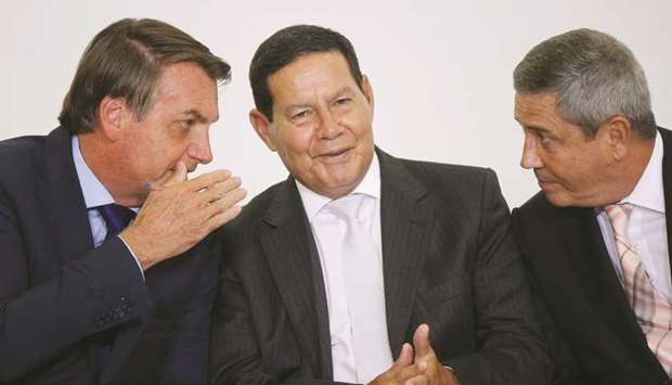 President Jair Bolsonaro speaks with Vice President Hamilton Mourao and chief of staff Minister Walter Souza Braga Netto during a ceremony at the Planalto Palace in Brasilia, Brazil.