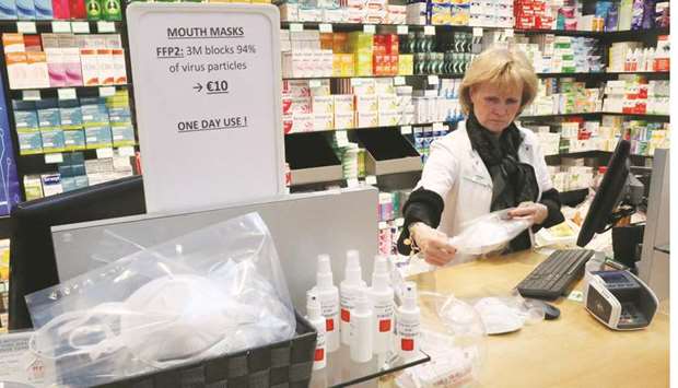 An employee in a drug store wraps protective face masks at Zaventem international airport, near Brussels.