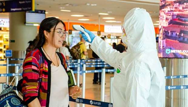 Health officials at Quito International Airport test visitors as part of coronavirus security measures in Quito, Ecuador