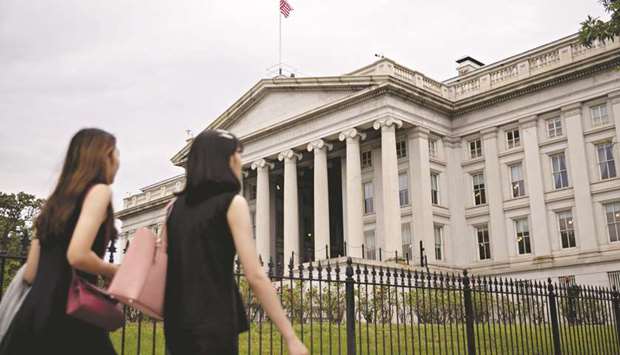Pedestrians walk near the US Treasury building in Washington, DC. Government debt racked up further historic milestones yesterday, with 30-year US yields sliding through 1.3% for the first time and Chinau2019s 10-year rates falling to the lowest since the country was battling deflation in 2002.