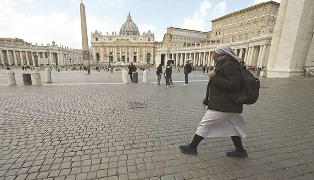 A nun walks on the normally-crowded Saint Peteru2019s Square.
